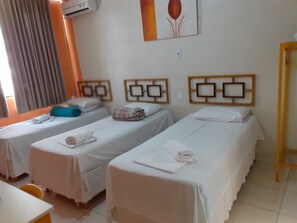 Ein Hotelzimmer mit zwei Einzelbetten, einem kleinen Tisch und einem Stuhl.