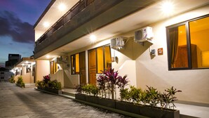A modern hotel with a two-story structure, outdoor lighting, and air conditioning units. - Dee Mansion Bali (Denpasar)