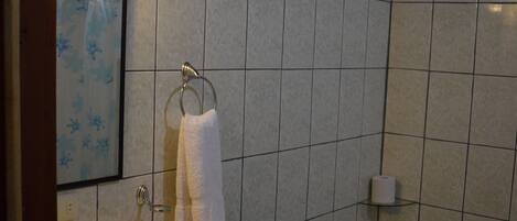 Een badkamer met een wastafel, toilet en spiegel.