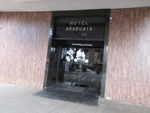 La entrada del Hotel Araguaia, con una puerta de vidrio y un toldo negro.