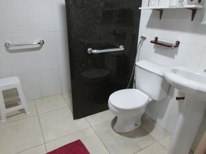A bathroom with a toilet, sink, and shower.