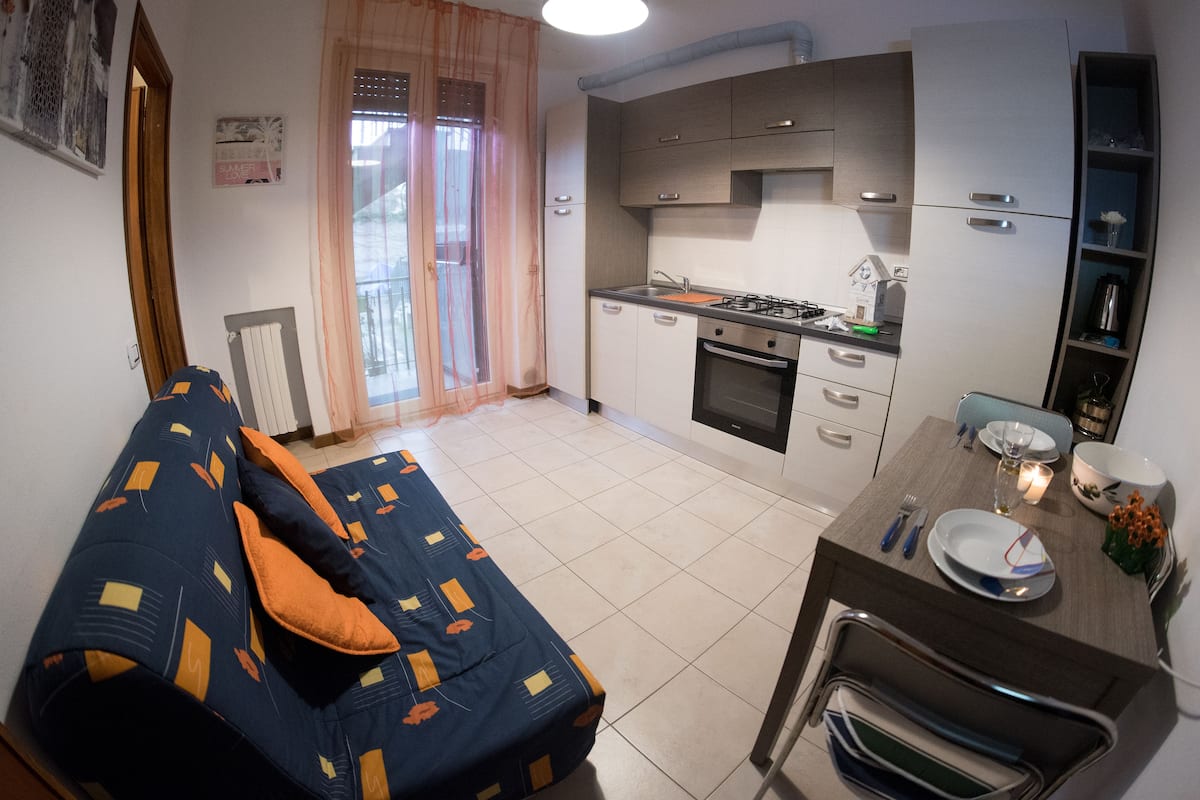 A compact living space with a sofa, dining table, and kitchenette.
