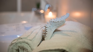 A towel with a textured, possibly knitted, design on a bathroom counter. - Le Dimore del Sole (Cagliari)
