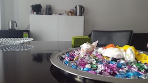 Una mesa con una bandeja de dulces envueltos y de colores variados.