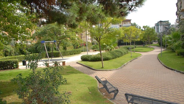 A park with a paved walkway, benches, and a swing set. - Le Dimore del Sole (Cagliari)