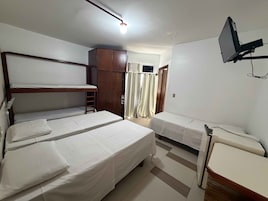 Una habitación con literas, un escritorio, una silla, un televisor y un armario.