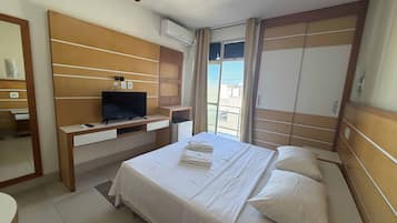 A hotel room with a bed, a TV, a desk, and a wardrobe.