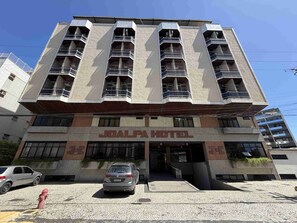 A multi-story building with a prominent 'JOALPA HOTEL' sign, a parking area, and a fire hydrant. - Joalpa Hotel Cabo Frio (Cabo Frio)