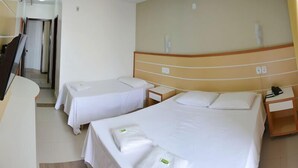 A hotel room with two beds, a TV, and a small table. - Joalpa Hotel Cabo Frio (Cabo Frio)