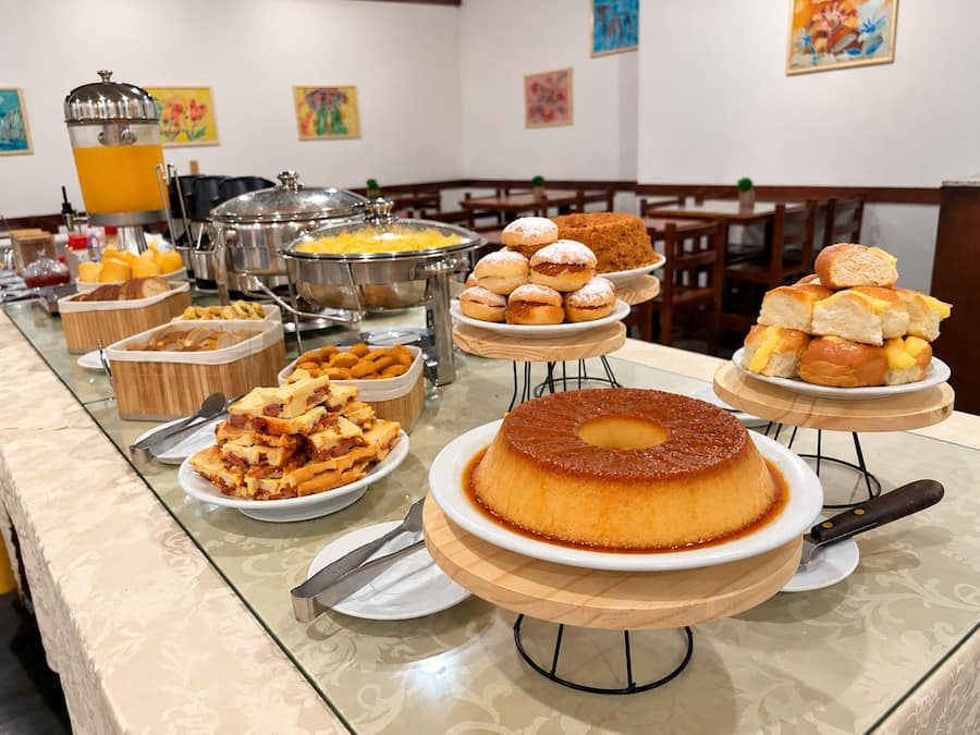 Un bufé con diversas opciones de comida, incluyendo un pastel grande sobre un pedestal.
