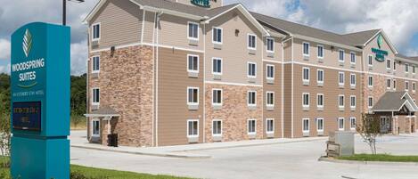 A multi-story hotel with a stone facade and a flat roof.