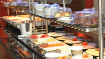 A buffet with various food items and a pitcher of milk.