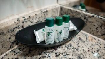 A black tray with three bottles of Green Tea on a granite countertop.