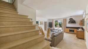 Un interior moderno con una escalera que conduce a un comedor y cocina.