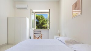 Une chambre à coucher comprenant un lit, une chaise, une table de chevet et une armoire.