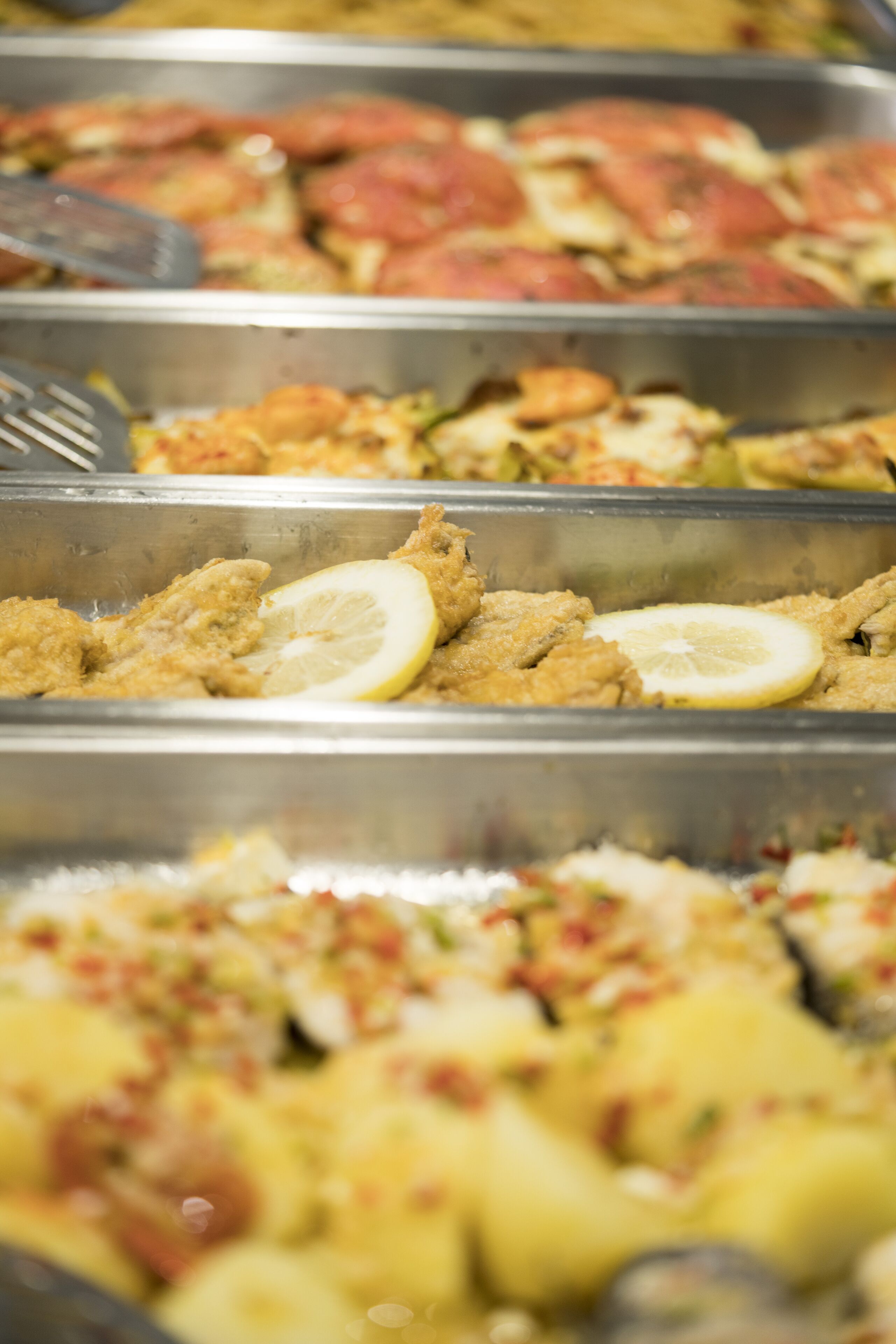 A buffet with various dishes, including fried items and a lemon slice garnish.