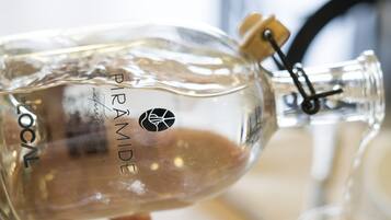 Una botella de vidrio transparente con corcho y cierre metálico, etiquetada como "PIRAMIDE LOCAL".