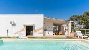 A modern house with a swimming pool, outdoor seating, and a kitchen area. - Villetta Marcella (Racale)