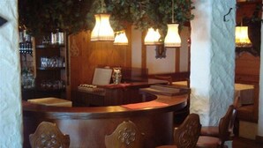 A bar area with wooden furniture, including a counter and bar stools. - Panorama (Finkenberg)