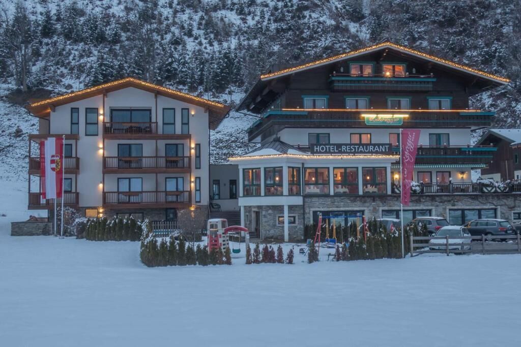 Un hotel con varios pisos, balcones y una zona de restaurante.