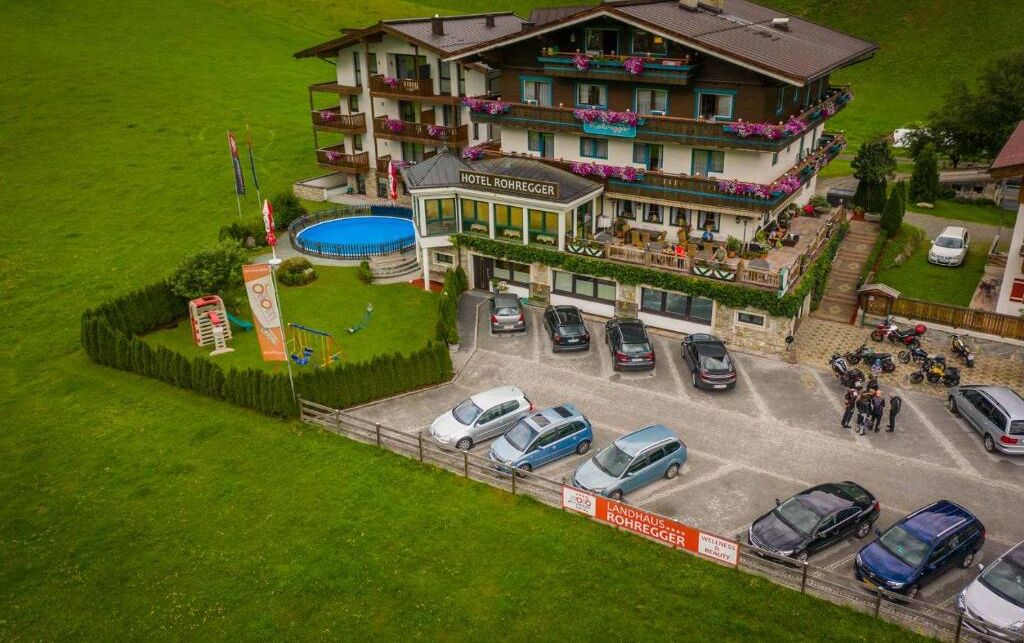Ein Hotel mit mehreren Balkonen, einem Swimmingpool und einem Parkplatz.