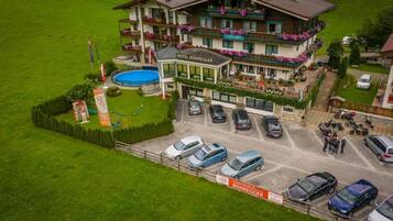 Ein Hotel mit mehreren Balkonen, einem Swimmingpool und einem Parkplatz.