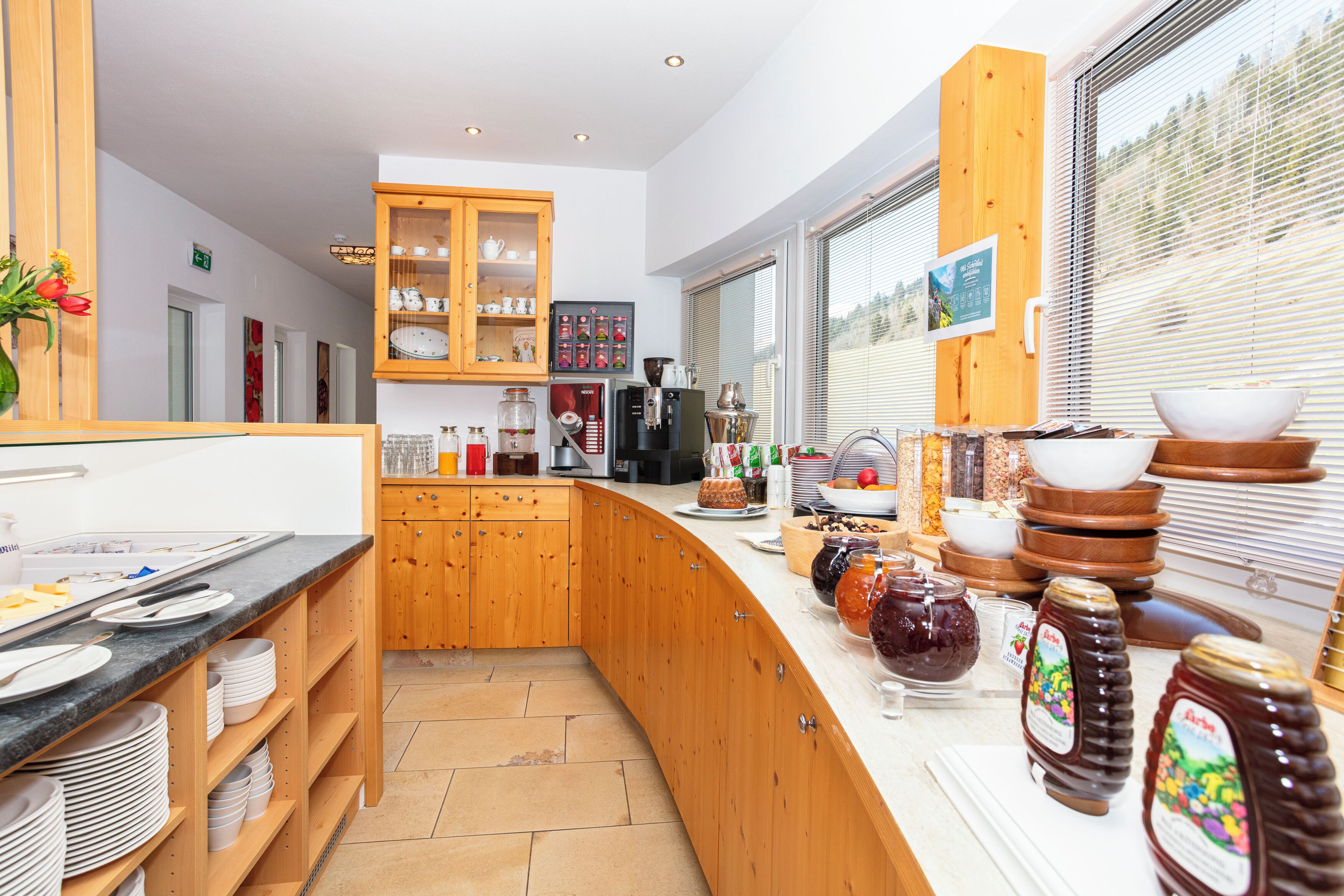 A modern kitchen with wooden cabinets, a marble countertop, and various kitchen appliances.