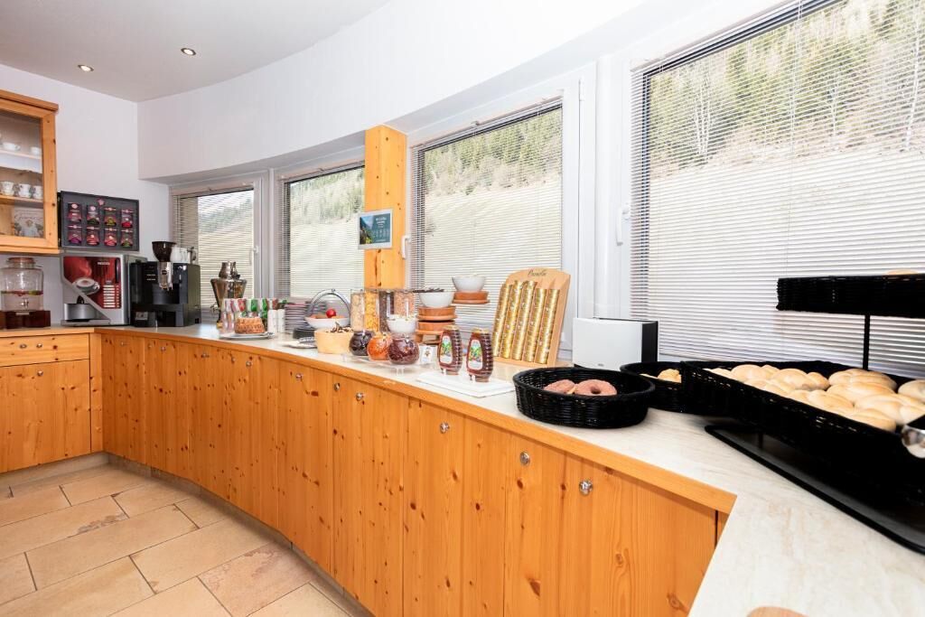 A kitchen with wooden cabinets, a coffee machine, and various food items on the counter.
