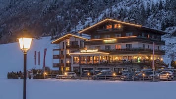 A hotel with a sign reading "HOTEL-RESTAURANT" in a snowy mountainous area.