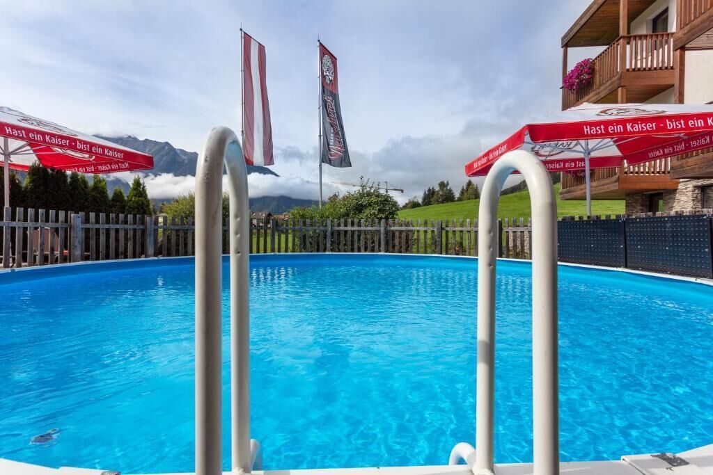 Une piscine avec deux drapeaux et une clôture en bois.