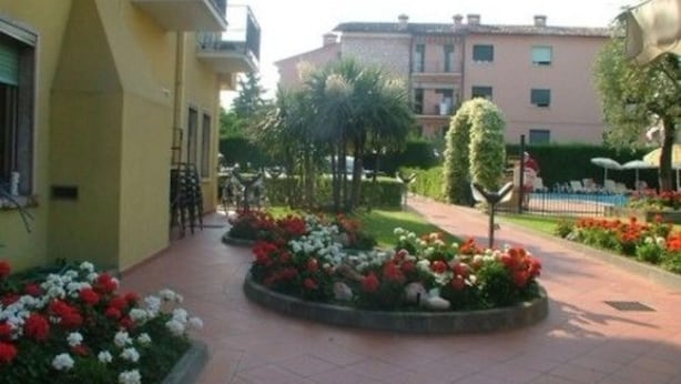 Un patio con parterres, un sendero y edificios con balcones.