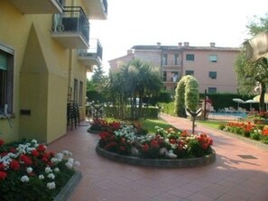 Un patio con parterres, un sendero y edificios con balcones.
