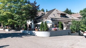 A building with outdoor seating and a covered patio area. - Sporthotel Spögler (Renon)