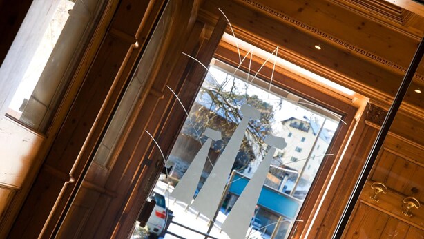 A wooden door with a glass panel, leading to a street view with parked cars and buildings. - Sporthotel Spögler (Renon)