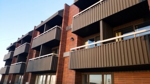A multi-story residential building with balconies, brick facade, and large windows. - Home Away Inn (Drayton Valley)