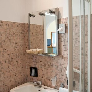 A bathroom with a mirror, sink, and towel rack. - Europa (Ispra)