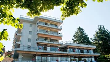 Un hotel a più piani con balconi, ampie finestre e tetto piano.