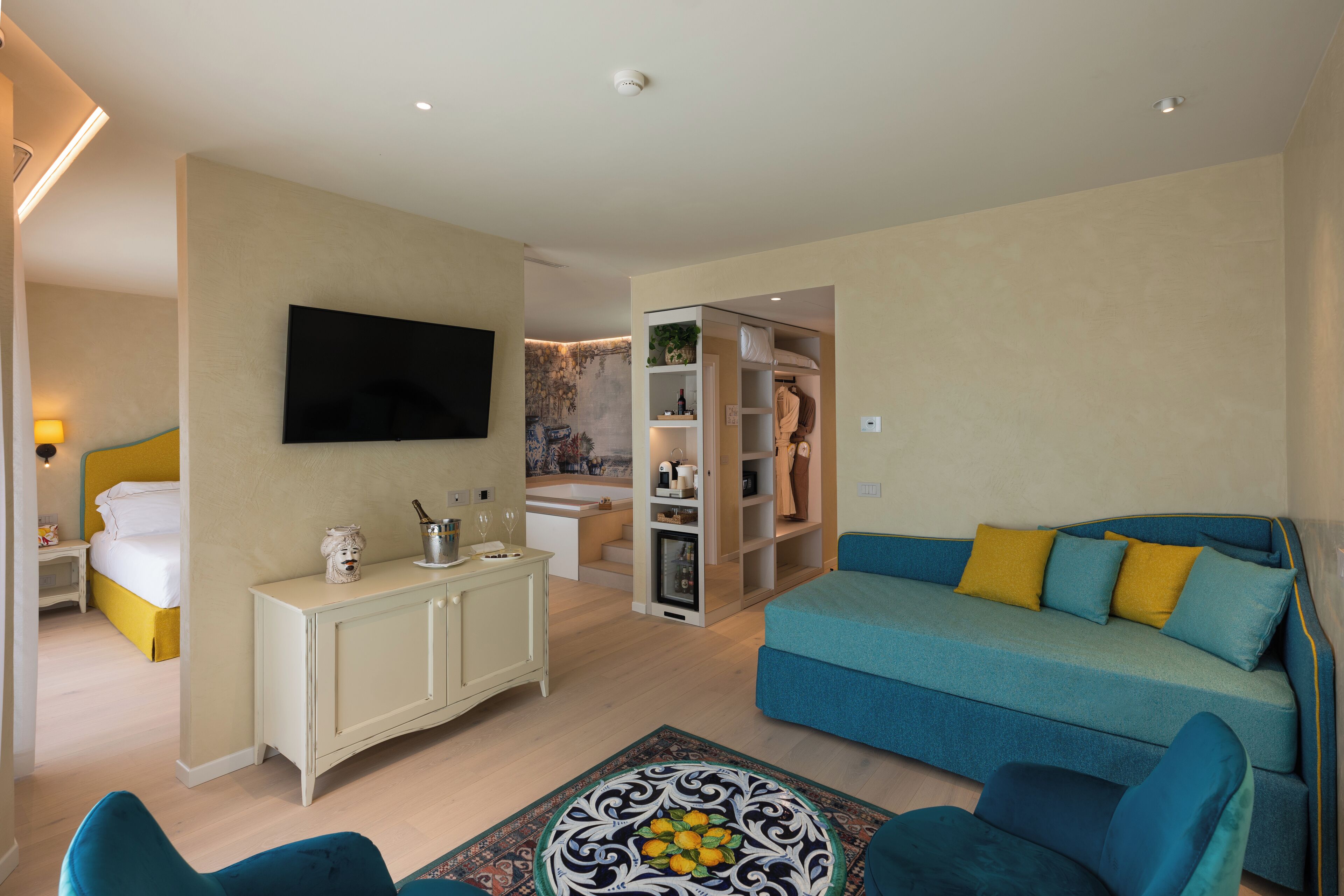 A modern living room with a sofa, a television, a cabinet, and a small table.