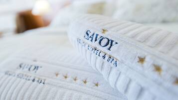 Primer plano de una toalla blanca con texto bordado y estrellas, probablemente de un hotel o spa.