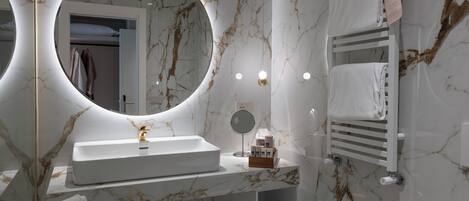 Un baño moderno con tocador de mármol, un bidé, un inodoro y un perchero para toallas.