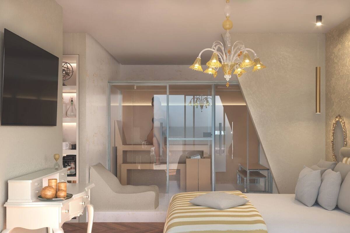 A modern bedroom with a bed, bedside table, and a chandelier.