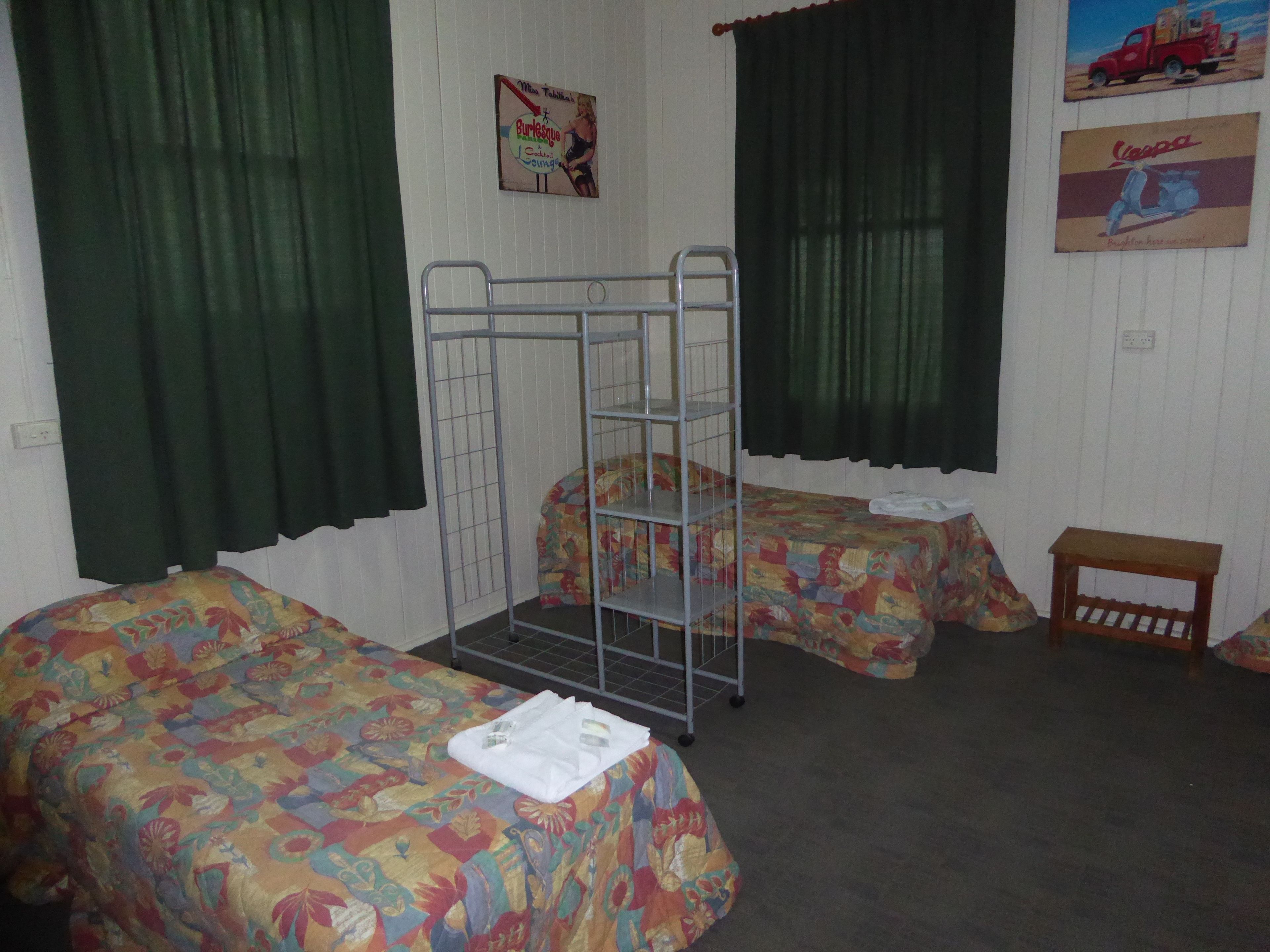 A room with two beds, a bunk bed, and a small wooden table.