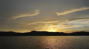 A sunset over a calm body of water with distant mountains. - Exchange Hotel Toogoolawah (Toogoolawah)