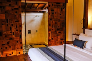 Um quarto com cama, painéis de parede de madeira, uma escada e uma porta.