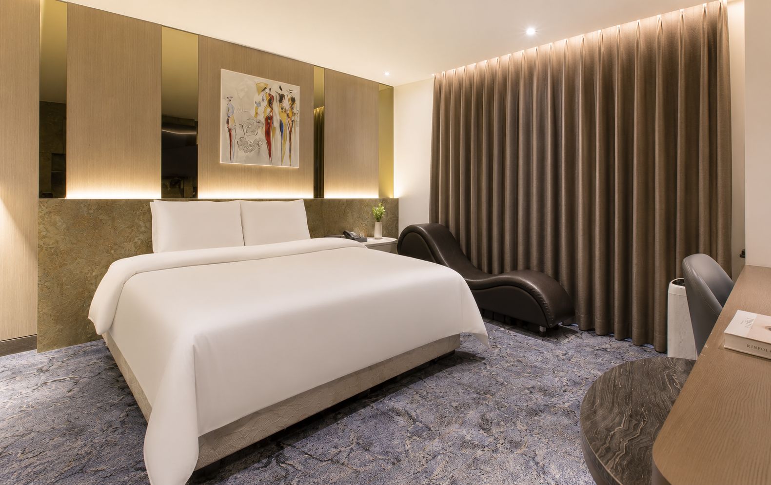 A modern hotel room with a large bed, a massage chair, a desk, and a large window with curtains.