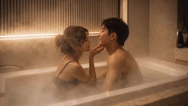 Un couple dans une baignoire remplie de vapeur, une fenêtre avec des stores et un mur en marbre.