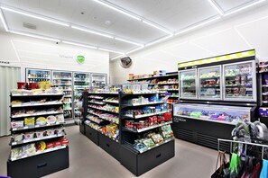 A grocery store with refrigerated sections, shelves stocked with various products, and a freezer area. - Guwol Hotel (Incheon)