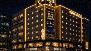 Un hôtel à plusieurs étages, doté d’une enseigne lumineuse et d’une devanture bien visible, portant le nom « Dessert 39 ».