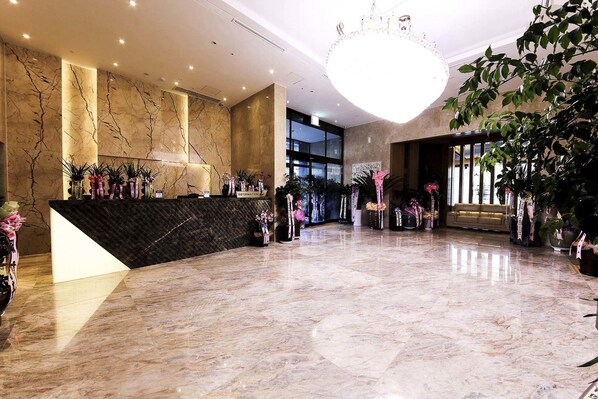 A spacious lobby with a marble floor, a reception desk, and a large chandelier. - Guwol Hotel (Incheon)