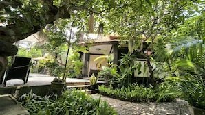 Un jardín exuberante con diversas plantas y una terraza de madera.